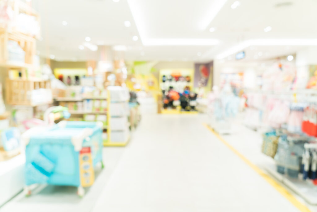 Vue en arrière-plan flou d'un magasin de puériculture, illustrant le service de tri et conseil en matériel de Parenthée.